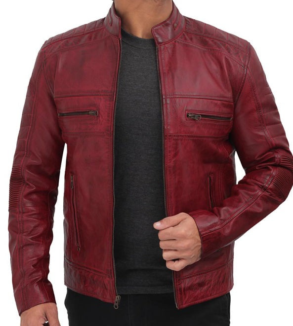 A man wearing a distressed red leather jacket over a dark gray t-shirt, shown from the neck down against a plain white background.