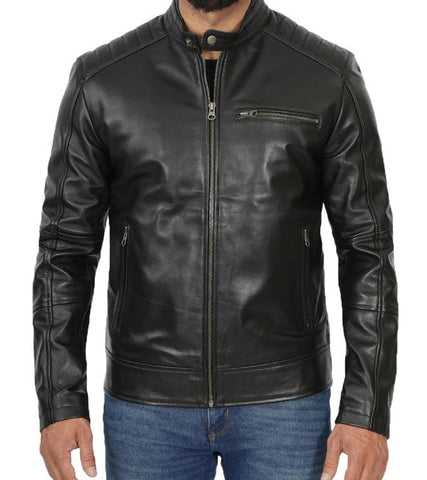 A man wearing a black leather jacket with a zip-up front, ribbed collar, and zippered chest pocket, paired with blue jeans against a plain white background.