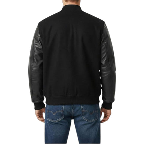 A man viewed from the back wearing a black bomber-style jacket with dark leather sleeves and blue jeans, against a plain white background.