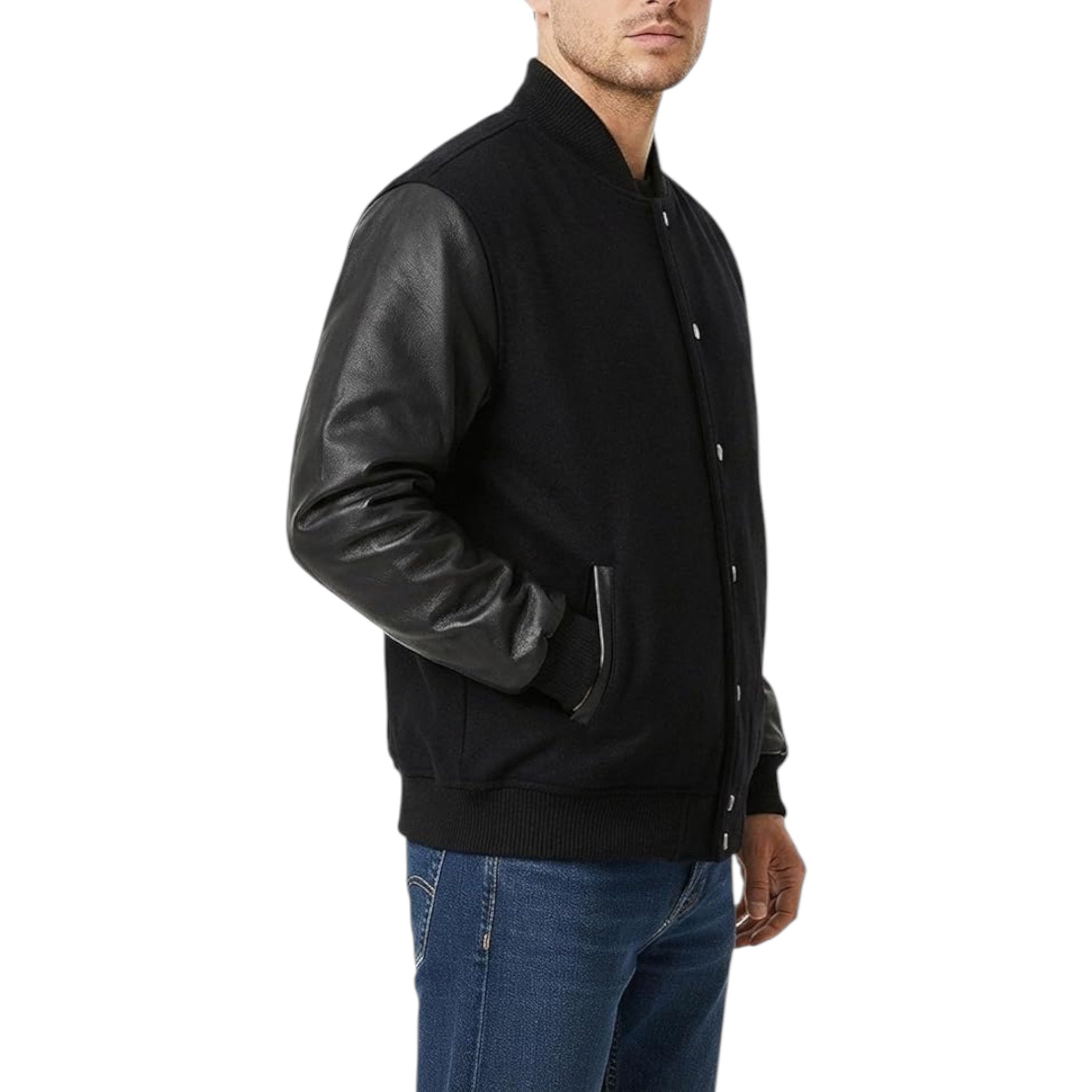 A man wearing a black knit and leather varsity-style jacket with dark leather sleeves, paired with blue jeans, shown from the side against a plain white background.