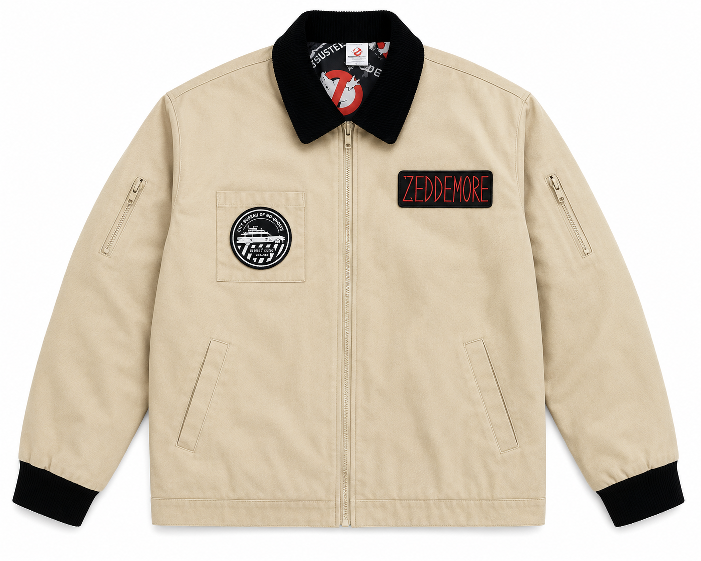 A beige zip-up jacket with a black collar, black cuffs, and black pocket trim. It features a circular patch on the left chest and a rectangular patch on the right chest that reads 'ZEDDEMORE' in red letters.