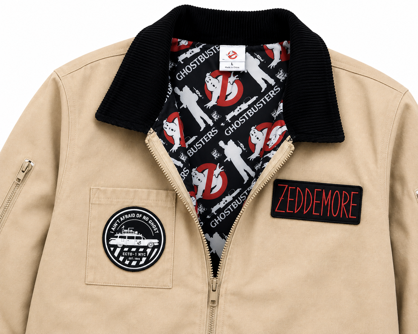 A beige zip-up jacket featuring a black ribbed corduroy collar, a Ghostbusters-themed lining, a circular patch on the chest pocket, and a 'ZEDDEMORE' name patch on the front.