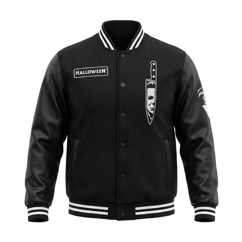 A black varsity-style jacket with white striped ribbed collar, cuffs, and hem, featuring a 'HALLOWEEN' patch on the right chest and a large knife graphic on the left chest, shown on a plain white background.