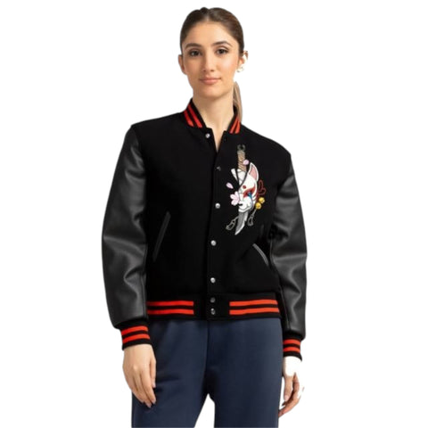 Woman wearing a black varsity jacket with red accents on a white background