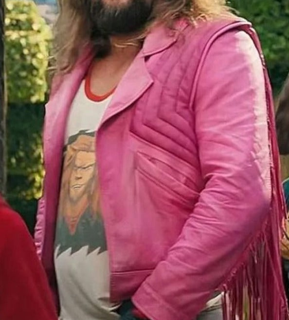 A person outdoors wearing a bright pink fringe leather jacket over a white graphic T-shirt.