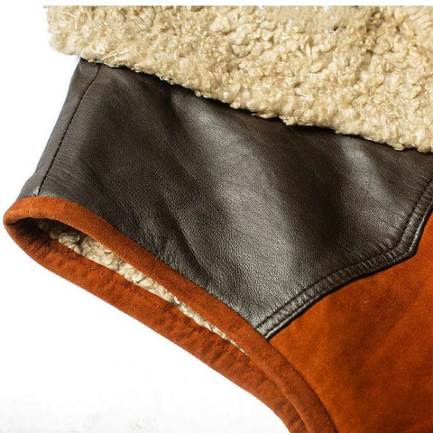 Close-up of a brown leather and suede sleeve with a beige sherpa lining, showing the texture and construction details.