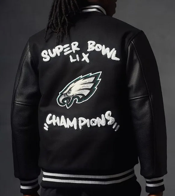 Back view of a person wearing a black varsity-style jacket with white and green Philadelphia Eagles graphics and the text 'SUPER BOWL LIX CHAMPIONS' on a dark gray background.