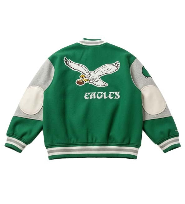 Green and gray varsity jacket shown from the back, featuring a large embroidered Philadelphia Eagles eagle logo and 'EAGLES' text on the back, with white elbow patches and striped ribbed collar, cuffs, and hem.