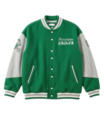 A green and gray varsity jacket with 'Philadelphia Eagles' text on the chest, featuring a green football helmet patch on the right sleeve and white button closures.
